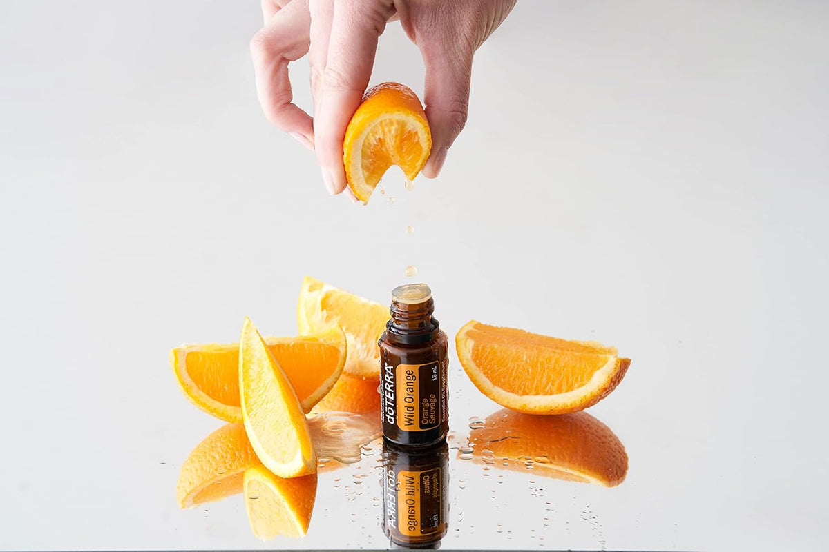 doTERRA Wild Orange Essential Oil 15 mL with fresh orange slices